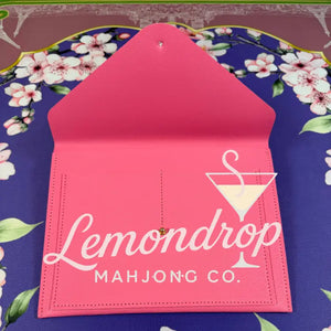 a pink envelope on a floral surface