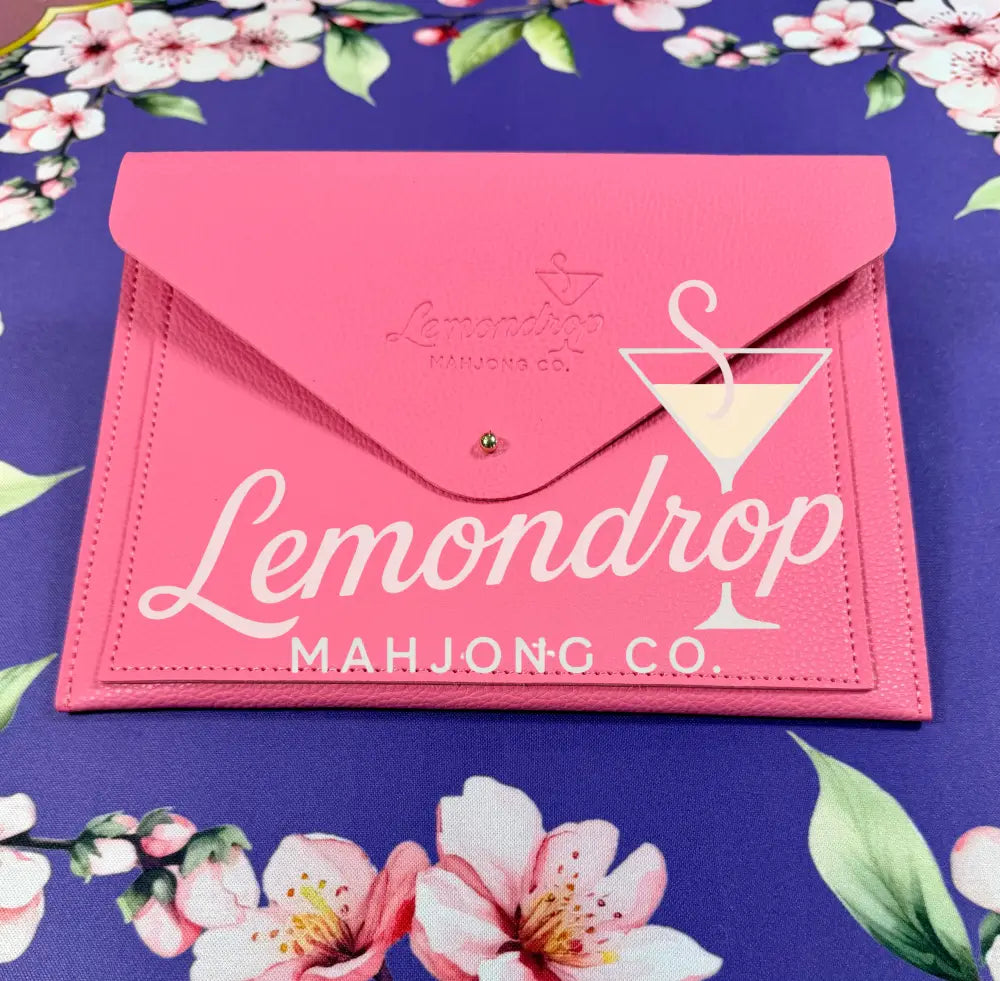 a pink envelope on a floral surface