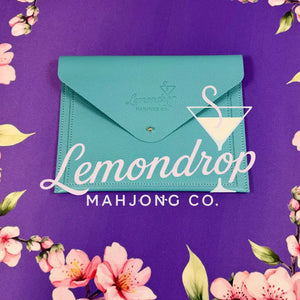 a blue envelope on a purple surface with pink flowers